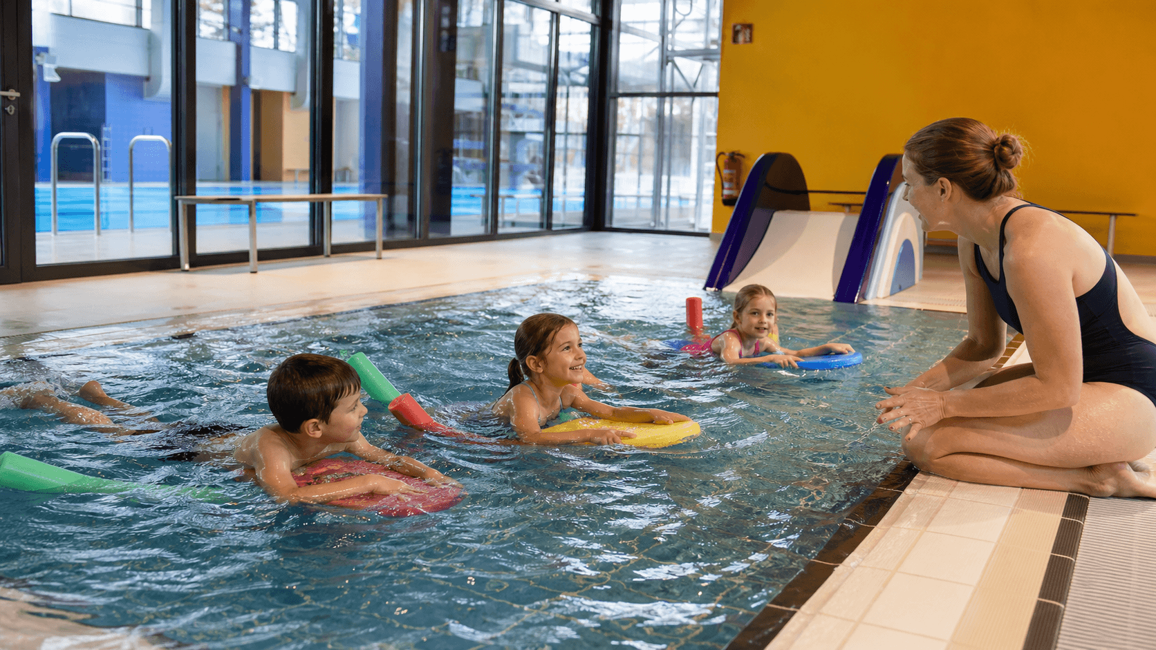 Schwimmtrainer unterstützen Kinder im Wasser